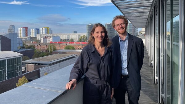 Dr. Verena Staats und Martin Lichte auf der Terrasse der Geschäftsstelle des Deutschen Vereins. Im Hintergrund blauer Himmel und Häuser – 